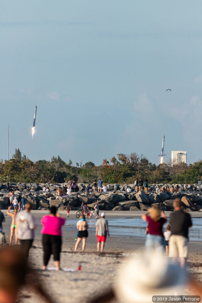 Two SpaceX Falcon Heavy boosters return to the Cape Canaveral Air Force Station after successfully launching the ARABSAT-6A satellite into orbit.